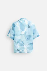 Camisa verde agua con estampado abstracto, corte relaxed fit, cuello solapa, manga corta y cierre frontal con botones.