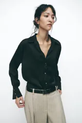 Camisa marrón satinada de cuello solapa, escote pico, manga larga y cierre frontal con botones.