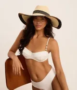 Sombrero de playa de paja color beige con cinta negra y ala ancha con pespuntes.