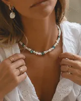 Collar corto de escallas de piedra natural blanca y cuadrados de nácar turquesa, con cierre de acero.