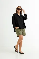 Camisa color beige de corte amplio, con cuello clásico, manga larga y bolsillo en el pecho.