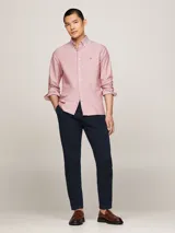 Camisa Tommy Hilfiger de corte slim fit, confeccionada en algodón Oxford con textura dobby. Diseño liso color salmón, con cuello abotonado, mangas largas con puños redondeados y logo bordado en el pecho.