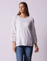 Blusa de broderie color blanco, de mangas largas con puños elásticos.