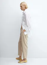 Pantalón fluido color beige, de corte recto y tiro alto, con cintura elástica y cordón ajustable. Presenta bolsillos laterales y diseño jogger.