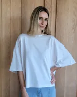 Remerón blanco de algodón, corte amplio y mangas cortas.