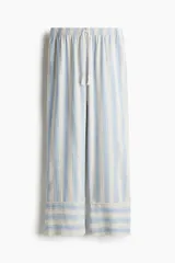 Pantalón de tejido liviano de mezcla de lino y viscosa a rayas celestes y blancas. Modelo de corte holgado con elástico revestido y cordón para ajustar en la cintura. Piernas rectas con bolsillos al bies.
