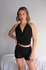 Conjunto de dos piezas (top y short) de lentejuelas color gris oscuro/plata. El top es estilo halter con escote drapeado y el short es tiro alto y ajustado.