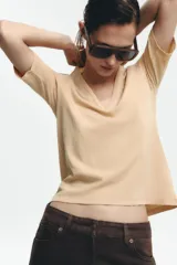 Camiseta color beige de lino con cuello en V y mangas cortas.