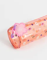 Cartuchera cilíndrica de PVC transparente con estampado de gatos, corazones y texto en japonés. Incluye cierre superior con dije de flor de acrílico.