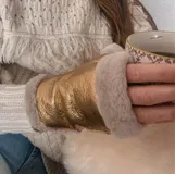 Guantes mitones de cuero de oveja color dorado con borde de piel sintética color crema.