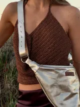 Top de crochet en hilo marrón con acabado brilloso. Diseñado con espalda libre y tiras ajustables que se atan atrás, este top realza la figura y suma un toque bohemio y sofisticado a cualquier look.