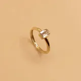 Anillo solitario dorado con circonia baguette rectangular.