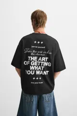 Camiseta negra de corte holgado, cuello redondo y manga corta. Estampado frontal con la frase "Take the risk or lose the chance" en color blanco.