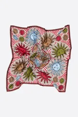 Pañuelo cuadrado con estampado de soles de colores sobre fondo a rayas rojas y blancas.