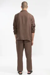 Pantalón marrón de lino 100% premium de alto gramaje, corte recto y fit relajado. Cintura con elástico y cordón de algodón, bolsillos laterales y traseros.