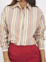 Camisa de manga larga con cuello clásico y cierre frontal con botones. Presenta un estampado de rayas verticales en tonos naranja, amarillo, gris y blanco.