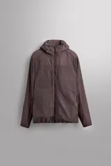 Cazadora marrón de tejido técnico ligero con partículas reflectantes. Tiene cuello alto con capucha elástica, mangas largas con puños elásticos, bolsillos frontales con cremallera en pecho y cadera, y cierre frontal con cremallera. Pertenece a la línea Zara Athleticz.