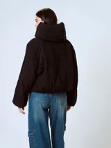 Campera puffer negra con diseño matelaseado de rombos, cuello alto y cierre con botones a presión.