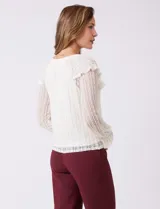 Blusa de encaje color beige de la marca Cupio, con cuello a la base y escote en V con lazo de ajuste. Presenta una sobrecapa de encaje con aplique de puntilla y mangas largas de encaje floral translúcido, terminadas en puños elásticos con volado. Incluye forro interno a tono.