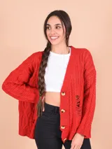 Cárdigan tejido de punto grueso color celeste con diseño trenzado y roturas. Tiene cuello en V, cierre frontal con botones y mangas largas.