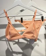 Conjunto de bikini color durazno, con corpiño triangular fijo y bombacha less.