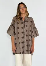 Camisa color lila con textura de lunares en relieve, de corte holgado, manga 3/4 con volados y cierre frontal con botones.