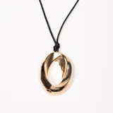 Colgante dorado en forma ovalada con tiento negro regulable.