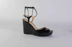 Sandalias negras de cuero con plataforma y tacón corrido de yute. Tiras finas de cuero que se atan al tobillo.