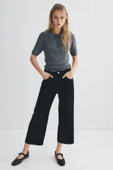 Pantalón de jean negro de corte ancho, tiro alto y largo cropped.