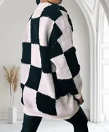 Sweater de punto con diseño de cuadros en blanco y negro, de manga larga y corte holgado.