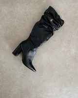 Bota negra de cuero vacuno con caña abullonada y taco de 10cm.