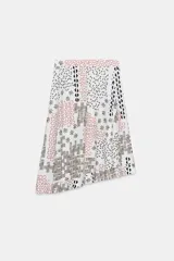 Falda midi de tiro alto confeccionada en hilatura con lino, color blanco con estampado geométrico en tonos marrones y rojizos. Cierre frontal cruzado con lazada a contraste en color negro.