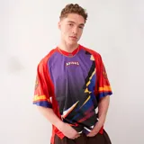 Camiseta de manga corta Adidas Originals, con cuello redondo acanalado y corte holgado. Diseño multicolor con paneles en rojo, violeta y negro, y logo de Adidas bordado en el pecho.