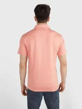 Chomba de piqué color salmón, de corte clásico, con cuello polo y tapeta de dos botones.