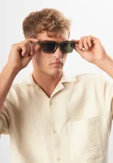 Lentes de sol Eco Shades modelo Romano con montura cuadrada azul traslúcido y lentes grises. Fabricados con acetato biodegradable y lentes de PMMA reciclado.