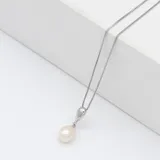 Collar con cadena tipo caja de plata 925 y dije colgante con una perla de río blanca de forma ovalada.