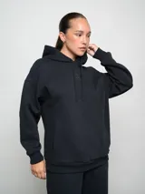 Buzo canguro con capucha color celeste, con logo de la marca bordado en el pecho.