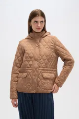 Campera blanca con diseño acolchado, cierre frontal con botones a presión y capucha desmontable.