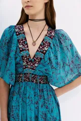 Vestido largo midi irregular de viscosa color celeste, con escote en V y mangas 3/4 amplias, con recorte elástico en la cintura.