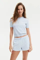 Remera celeste de punto fino suave, corte entallado, cuello redondo, mangas cortas y terminaciones acanaladas.