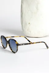 Lentes de sol redondos con montura carey y lentes degradados azules.