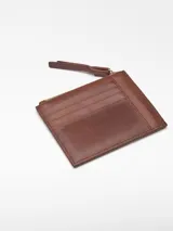 Monedero mediano de piel craquelada color marrón, con curtición vegetal. Tiene un compartimento con cierre de cremallera, tarjetero en la parte trasera y logo grabado.