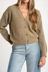 Cardigan de punto acanalado color tostado, con calce oversize, escote en V y cierre frontal con cuatro botones. Presenta manga larga con hombros caídos y está confeccionado en una mezcla de lana y nylon.