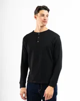 Remera de manga larga negra, confeccionada en tela tipo mini piqué de algodón, con cuello redondo y cierre de medio cuello con tres botones.