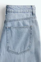 Pantalón de jean celeste de tiro alto, corte amplio y cinco bolsillos.