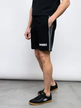 Bermuda deportiva azul marino de piqué con cintura elástica ajustable con cordón, bolsillos laterales y logo Umbro bordado en blanco.