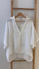 Blusa azul marino de lino, con cuello camisero que forma un escote en V, mangas cortas dobladas y calce holgado.