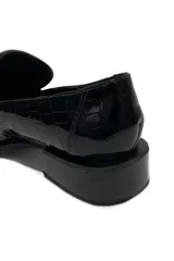 Mocasín negro de charol, 100% cuero con detalle de textura y altura de taco de 3 cm.