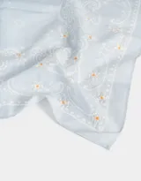 Pañuelo de algodón color crema con estampado de cachemira en negro y detalles florales en rosa.