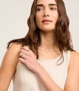 Musculosa sin mangas color crudo, confeccionada en sarga con efecto lino y cuello redondo.